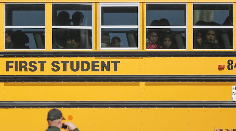 Kids watch a police officer investigate their school bus that collided with another bus on Jan. 26 in Wichita, Kan. According to police, 27 children suffered minor injuries. Legislative momentum in a number of states is building behind seat belt requirements on school buses. (Travis Heying/Wichita Eagle/TNS)