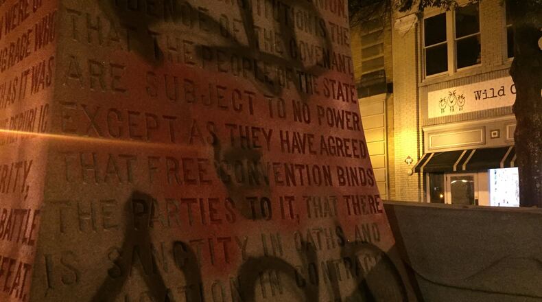 The Confederate monument in Decatur Square is dismantled and removed after midnight on June 19, 2020. The base of the monument, shown here loaded on a truck on Ponce de Leon Ave. following its removal, was engraved on all four sides with text glorifying the Confederacy. One side is engraved “ERECTED by the men and women and children of DeKalb County to the memory of the soldiers and sailors of the Confederacy, of whose virtues in peace and in war we are witnesses to the end that justice may be done and that the truth perish not. Graffiti painted over the text on two other sides that called Confederates “a covenant keeping race who held fast to the faith as it was given by the fathers of the Republic” and who believed that “there is sanctity in oaths and obligation in contracts” (that side shown here), apparent references to the original U.S. Constitution, which provided for states to allow slavery. The graffiti on those two sides is a background of red paint with a black stencil of the face of George Floyd in the center. This side is also painted with the words “RIP Floyd”. (PHOTO by Ariel Hart / ahart@ajc.com)