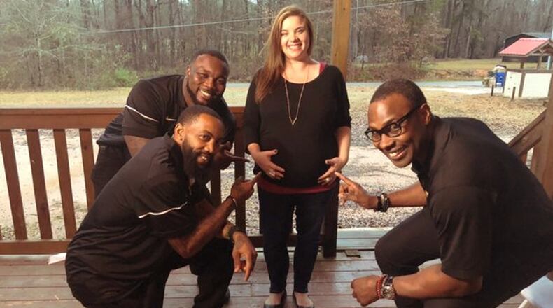 Mary Hall, who is expecting twins, poses with former NFL players who came bearing gifts donated by Kids II. Hall’s husband, Jonathon, was among members of the Georgia National Guard being deployed to Afghanistan. CONTRIBUTED