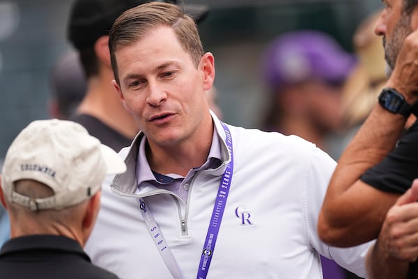 Walker Monfort, the Colorado Rockies vice president of corporate sponsorships, talks with onlookers before a baseball game against the Los Angeles Dodgers, Wednesday, June 25, 2025, in Denver. (AP Photo/David Zalubowski)