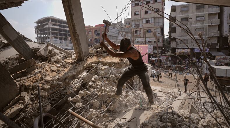 Palestinians remove iron from the rubble of buildings destroyed by Israeli airstrikes during the war with Hamas, repair and recycle it for construction, building tents or selling it, in Gaza City, Sunday, Aug. 16, 2026. (AP Photo/Jehad Alshrafi)
