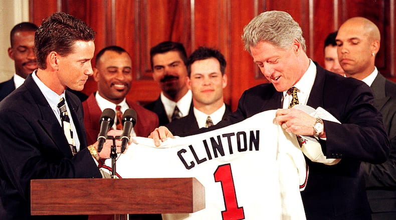 The World Champion Atlanta Braves of 1996 visit the White House. Tom Glavine, the winner of series-clinching Game 6 against Cleveland, presents President Bill Clinton with a Braves uniform top. Picture in the background from left to right: Fred McGriff, Dwight Smith, Eddie Perez, Mike Mordecai, Greg Michael and David Justice. (Photo by Rick McKay/Cox Washington Bureau)