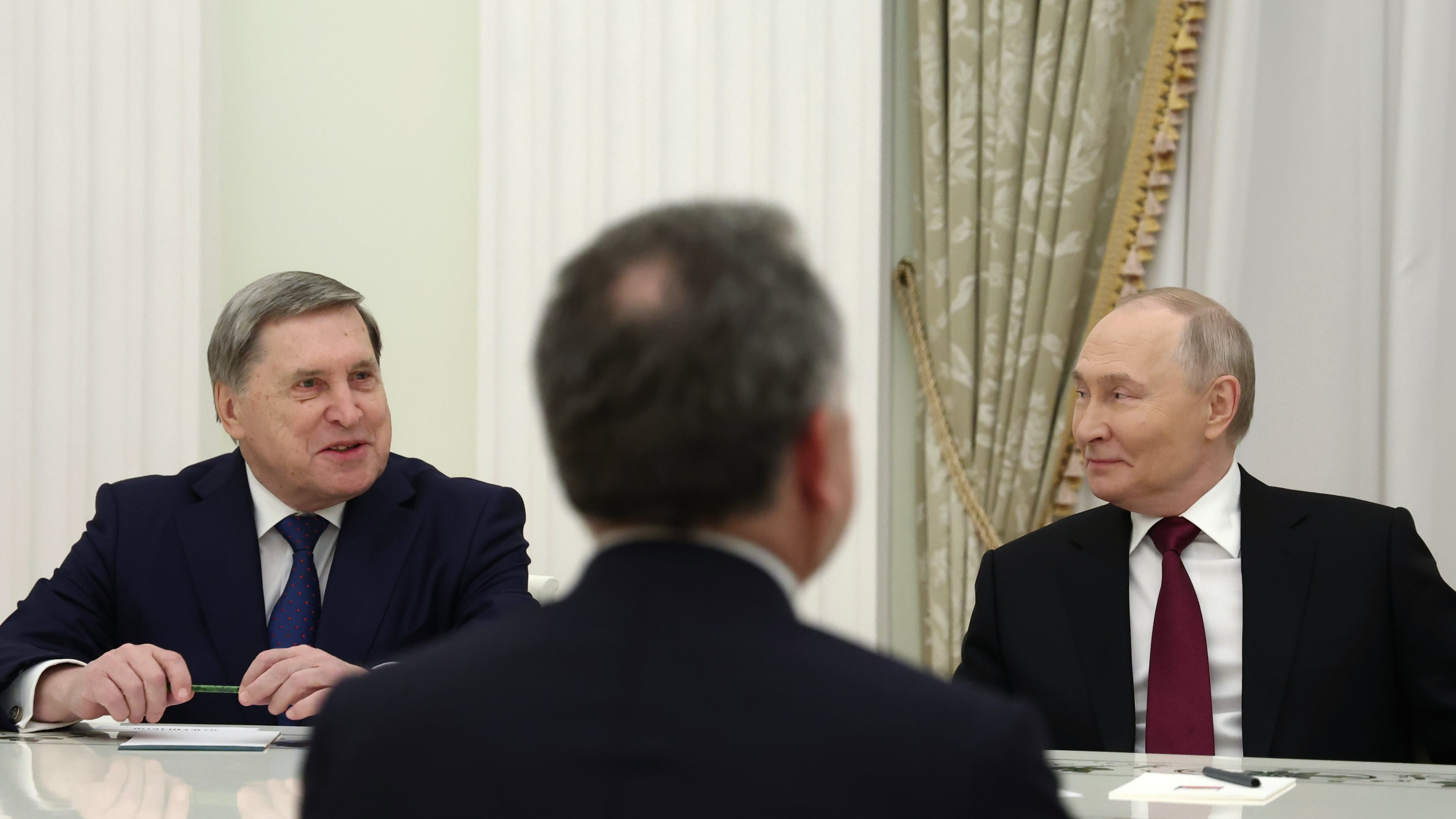Russian President Vladimir Putin, right, and Russian Presidential foreign policy adviser Yuri Ushakov, left, attend the talks with U.S. special envoy Steve Witkoff, back to a camera, at the Senate Palace of the Kremlin in Moscow, Russia, Tuesday, Dec. 2, 2025. (Alexander Kazakov, Sputnik, Kremlin Pool Photo via AP)
