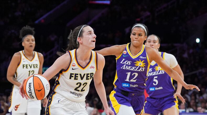 Indiana Fever guard Caitlin Clark (22) drives past Los Angeles Sparks guard-forward Rae Burrell (12) during the first half of a WNBA basketball game Wednesday, May 13, 2026, in Los Angeles. (AP Photo/Jae C. Hong)