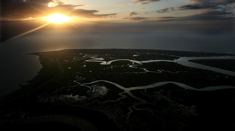 The sun bursts through the clouds at sunrise over Tybee Island on Friday, May 25, 2007. Georgia's coast stretches for approximately 100 miles from the Savannah River at Tybee Island to the St. Marys River in the south.