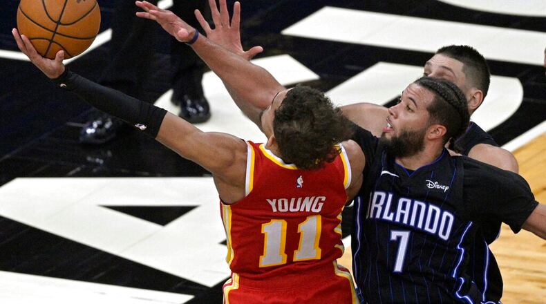 Atlanta Hawks guard Trae Young (11) is fouled by Orlando Magic guard Michael Carter-Williams (7) while going for a shot near the end of the second half of an NBA basketball game, Wednesday, March 3, 2021, in Orlando, Fla. (AP Photo/Phelan M. Ebenhack)