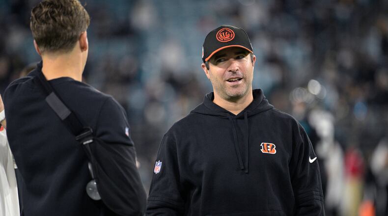 Cincinnati Bengals offensive coordinator Brian Callahan, right, talks with quarterback Joe Burrow on the field before an NFL football game against the Jacksonville Jaguars, Monday, Dec. 4, 2023, in Jacksonville, Fla. (AP Photo/Phelan M. Ebenhack)