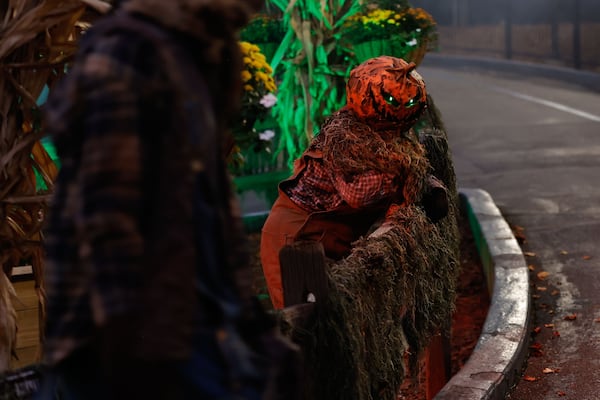 A rotten pumpkin character waits to scare park guests inside of Fright Fest scare zone "The Rotten Ones" at Six Flags Over Georgia. (Natrice Miller/ AJC)