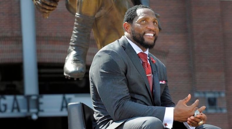 Ray Lewis sits in front of the bronze statue of himself that was unveiled at M&T Bank Stadium in Baltimore on Sept. 4, 2014. (Lloyd Fox/Baltimore Sun/TNS)