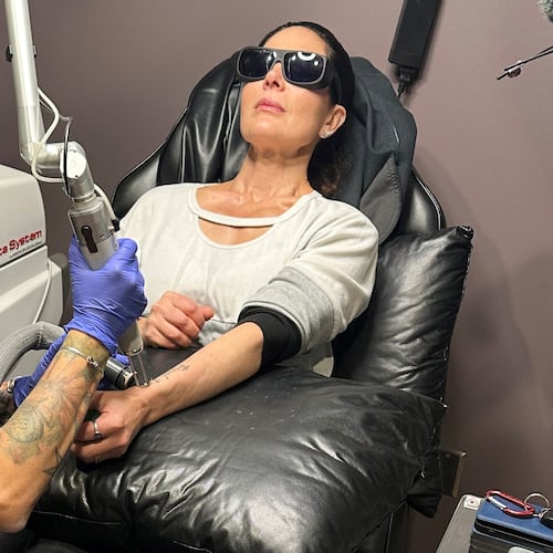 Tracy Herrmann has one of her tattoos removed by Chroma Tattoo Studio Laser Tattoo Removal owner Jaime Howard on Nov. 19, 2025, in West Bloomfield, Mich. (AP Photo/Corey Williams)