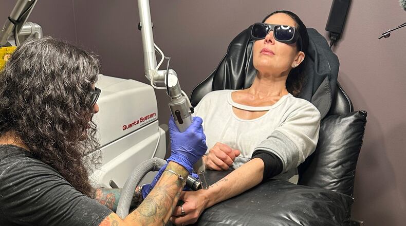 Tracy Herrmann has one of her tattoos removed by Chroma Tattoo Studio Laser Tattoo Removal owner Jaime Howard on Nov. 19, 2025, in West Bloomfield, Mich. (AP Photo/Corey Williams)