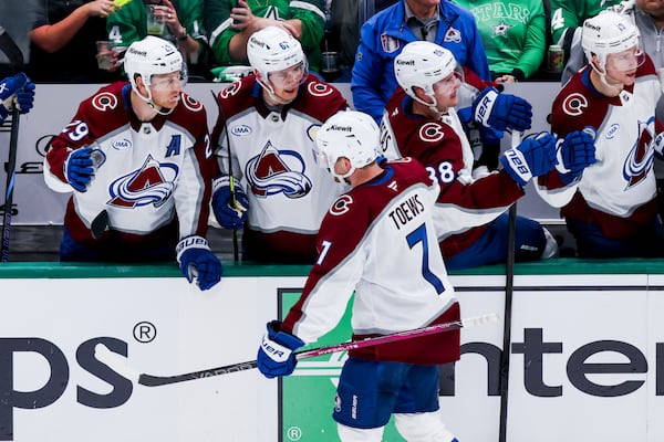 Colorado Avalanche defenseman Devon Toews (7) celebrates with teammates after scoring during a first-round NHL hockey playoff game against the Dallas Stars in Dallas, Saturday, April 19, 2025. (AP Photo/Gareth Patterson)