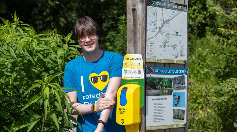 Ellis Schroeder with one of the sunscreen dispenser he maintains at the Zonolite Park entrance in Atlanta. At age 16, Schroeder is a huge advocate for education, awareness & protection against skin cancer. PHIL SKINNER FOR THE ATLANTA JOURNAL-CONSTITUTION