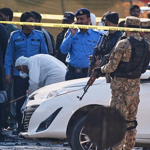 Pakistani investigators examine a damage car at the site of a suicide bombing outside the gates of a district court, in Islamabad, Pakistan, Tuesday, Nov. 11, 2025. (AP Photo/Ahsan Shahzad)
