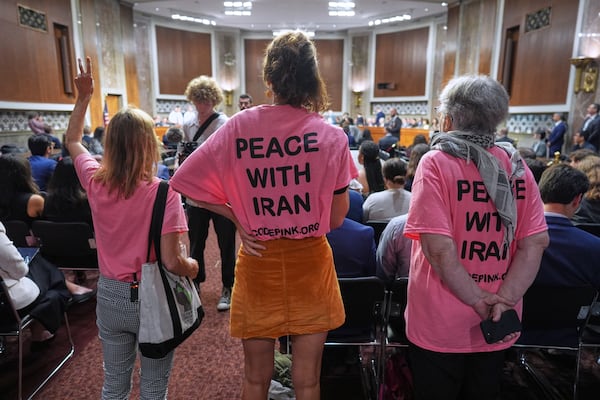 Activists stand up in the hearing room as Secretary of Defense Pete Hegseth arrives to field questions on the Pentagon budget and the crisis between Iran and Israel from the Senate Armed Services Committee, at the Capitol in Washington, Wednesday, June 18, 2025. (AP Photo/J. Scott Applewhite)