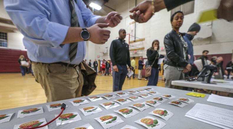 Voting stickers are handed out at Henry W. Grady High School in Atlanta as voters in Georgia cast their ballots Tuesday, Mar. 1, 2016 in the presidential primary. JOHN SPINK / JSPINK@AJC.COM