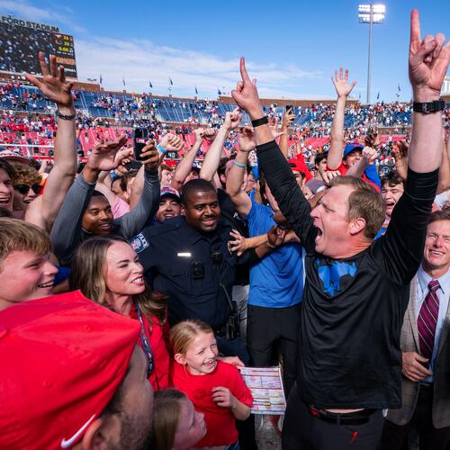 SMU head coach Rhett Lashlee celebrates on the field with fans after his team's 26-20 overtime win over Miami in an NCAA college football game, Saturday, Nov. 1, 2025, in Dallas. (AP Photo/Jeffrey McWhorter)