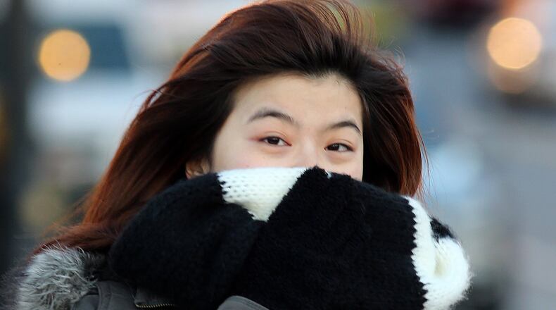 Miki Wang, a Georgia Tech student from Taiwan, bundles up against the bone-chilling wind while walking back to her apartment after shopping Monday evening Jan. 6, 2014. BEN GRAY / BGRAY@AJC.COM
