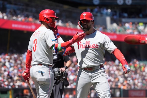 Philadelphia Phillies' Kyle Schwarber, right, is congratulated by Bryce Harper after hitting a three-run home run that also scored J.T. Realmuto and Trea Turner during the eighth inning of a baseball game against the San Francisco Giants in San Francisco, Wednesday, July 9, 2025. (AP Photo/Jeff Chiu)