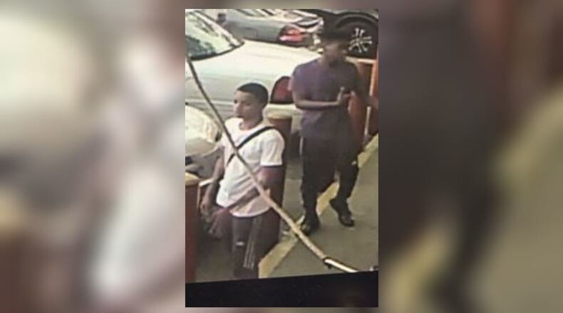 This surveillance photo shows the two persons of interest in connection with a shooting death. (Credit: Fulton County Police Department)