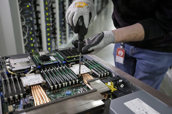 A Microsoft technician works on a computer server rack. The Northern Virginia Datacenter Academy, through a partnership with Microsoft, helps train underrepresented communities. Two similar programs are planned in metro Atlanta. (Courtesy of Microsoft)