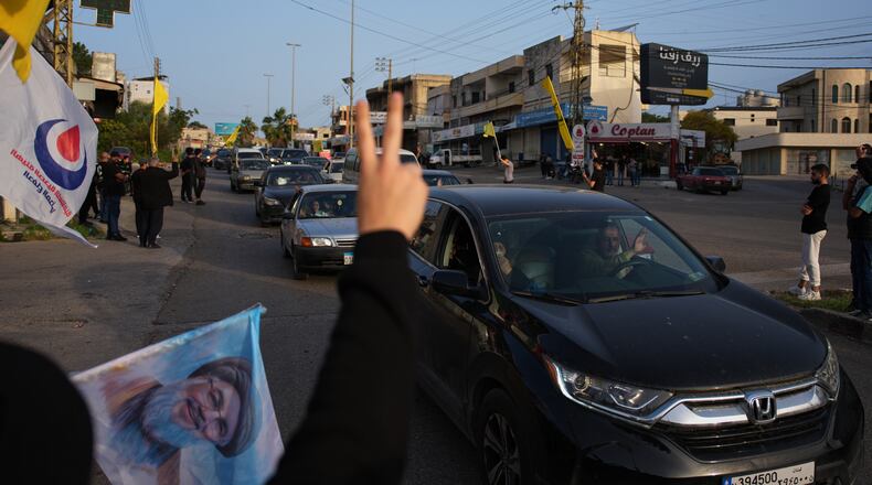 Displaced residents drive back to their villages as locals wave Hezbollah flags and an image of late Hezbollah leader Hassan Nasrallah, in Zefta, southern Lebanon, Friday, April 17, 2026, following a ceasefire between Israel and Hezbollah. (AP Photo/Hassan Ammar)