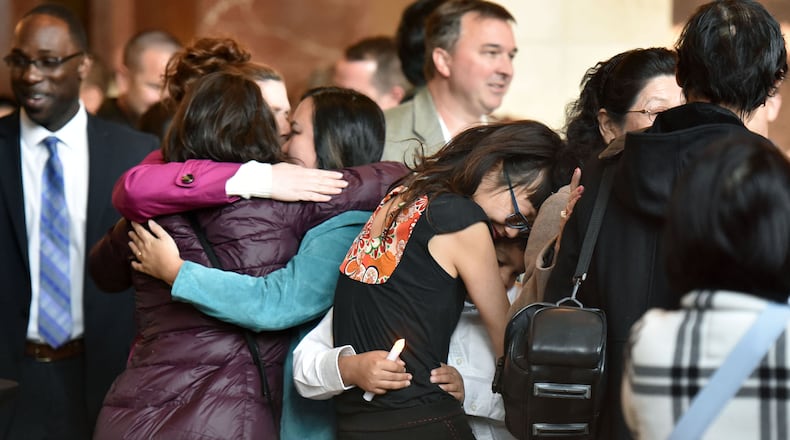 Family members, friends and community members gathered Thursday night for a candlelight vigil for Trinh Huynh, and Atlanta attorney shot to death in Midtown. (HYOSUB SHIN / HSHIN@AJC.COM)