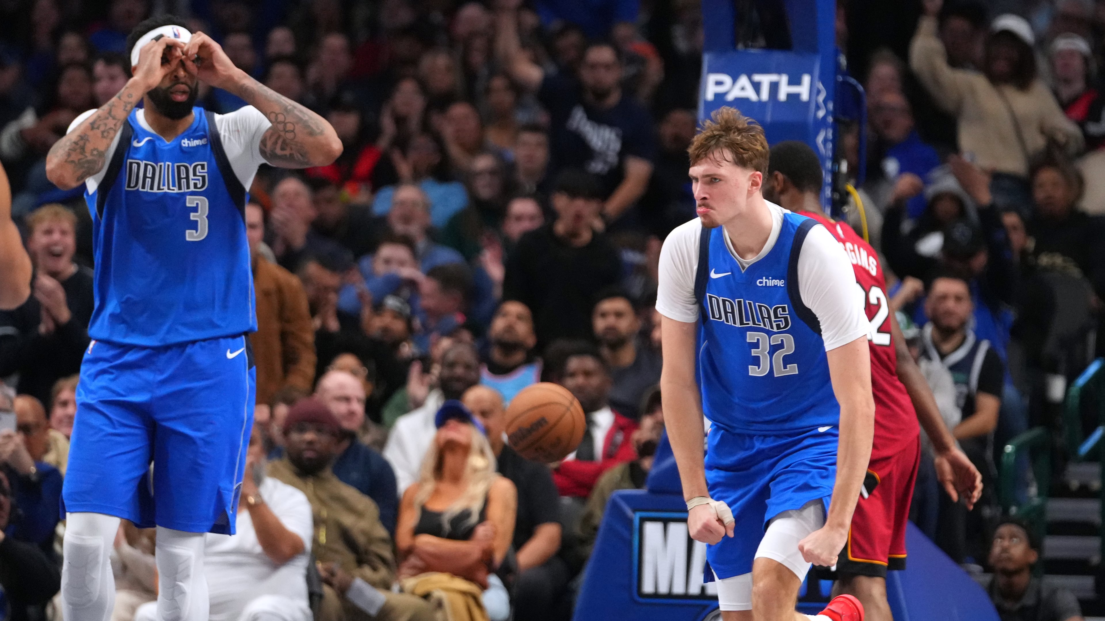 Dallas Mavericks forward Cooper Flagg (32) and forward Anthony Davis (3) react after a basket against the Miami Heat during the second half of an NBA basketball game Wednesday, Dec. 3, 2025, in Dallas. (AP Photo/Julio Cortez)