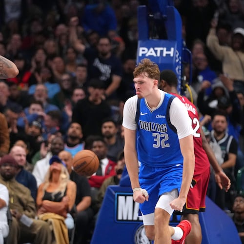 Dallas Mavericks forward Cooper Flagg (32) and forward Anthony Davis (3) react after a basket against the Miami Heat during the second half of an NBA basketball game Wednesday, Dec. 3, 2025, in Dallas. (AP Photo/Julio Cortez)