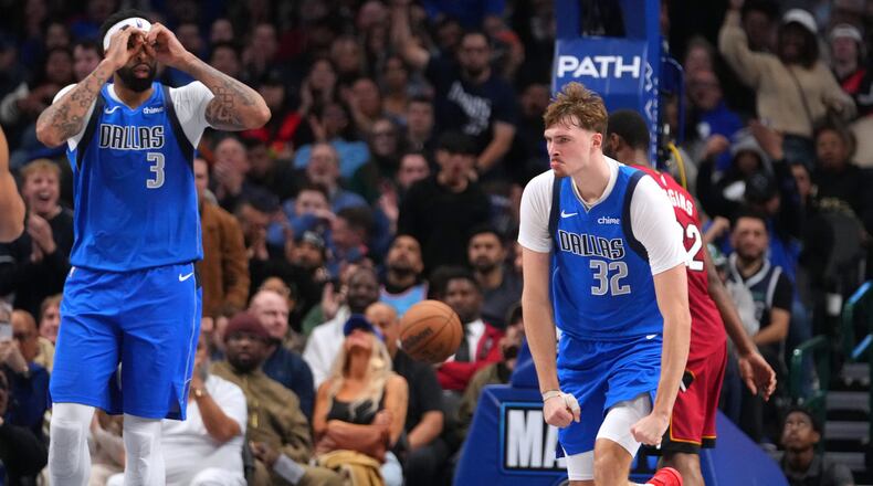 Dallas Mavericks forward Cooper Flagg (32) and forward Anthony Davis (3) react after a basket against the Miami Heat during the second half of an NBA basketball game Wednesday, Dec. 3, 2025, in Dallas. (AP Photo/Julio Cortez)
