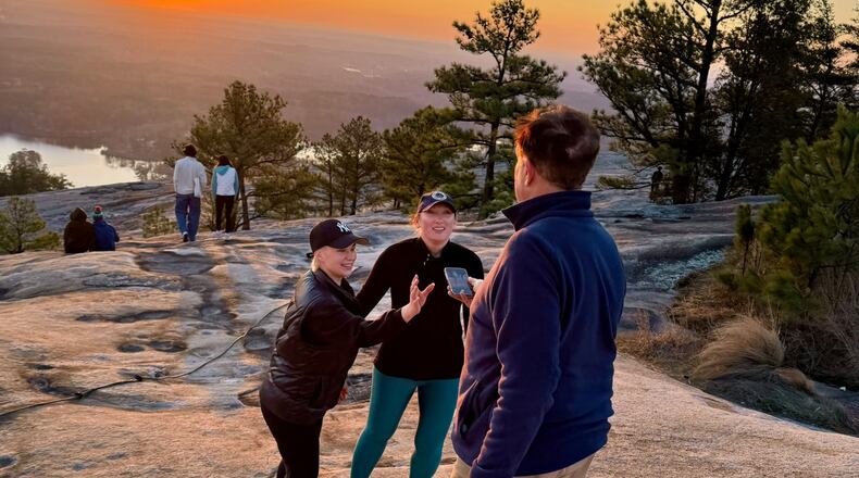 Emory Morsberger takes a photo of a family visiting Stone Mountain at sunrise. He has committed this random act of kindness thousands of times.