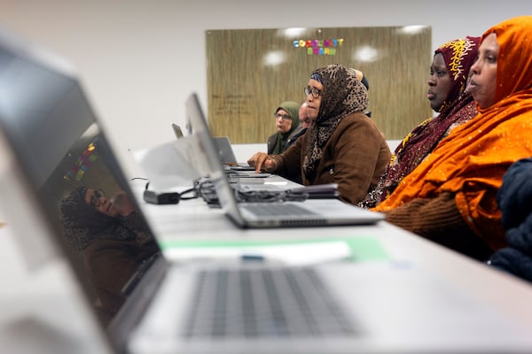 Rugaya Ismail, center, is reflected in a computer screen during a keyboard basics class offered by Free Geek on Thursday, May 15, 2025, in Portland, Ore. (AP Photo/Jenny Kane)