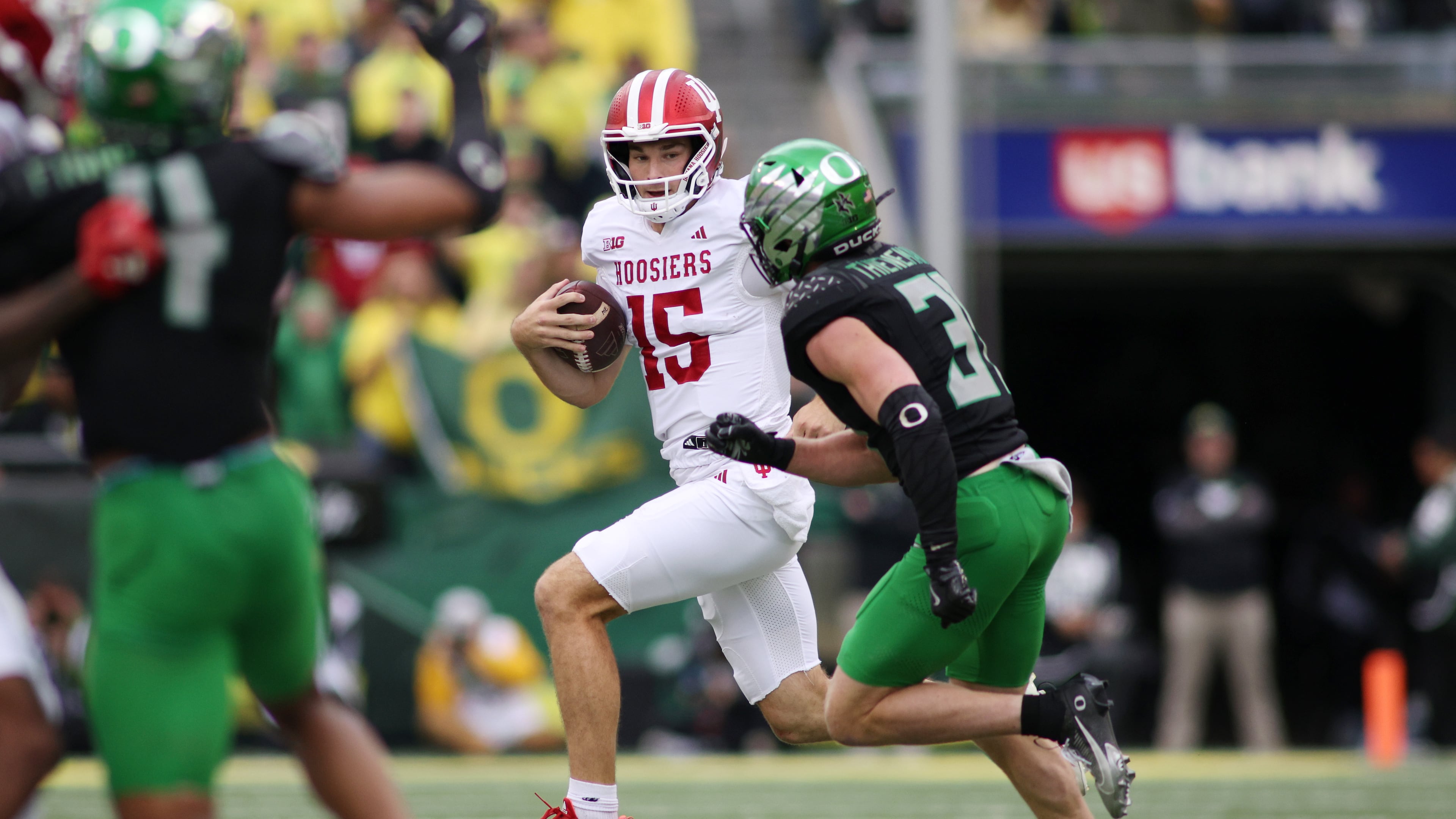 Indiana quarterback Fernando Mendoza (15) runs the ball while defended by Oregon defensive back Dillon Thieneman, right, during the first half of an NCAA college football game, Saturday, Oct. 11, 2025, in Eugene, Ore. (AP Photo/Lydia Ely)