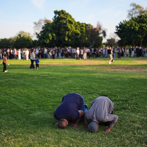 Two people pray during a vigil, the day after a shooting, outside of the Islamic Center of San Diego, Tuesday, May 19, 2026, in San Diego. (AP Photo/Jae C. Hong)