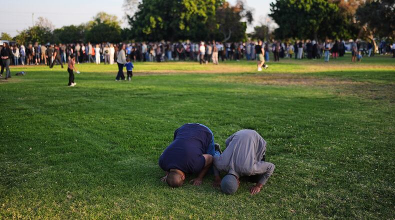 Two people pray during a vigil, the day after a shooting, outside of the Islamic Center of San Diego, Tuesday, May 19, 2026, in San Diego. (AP Photo/Jae C. Hong)