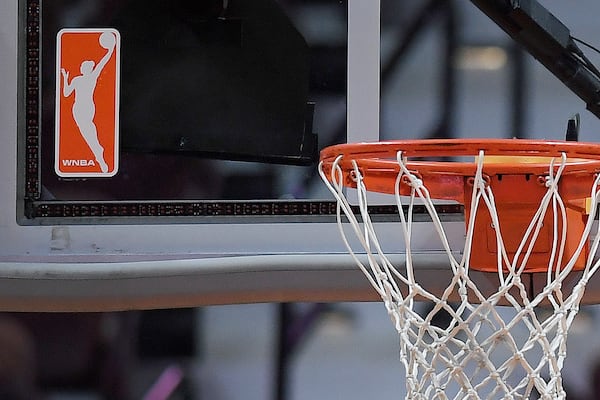 FILE - The WNBA logo is seen near a hoop before an WNBA basketball game at Mohegan Sun Arena, Tuesday, May 14, 2019, in Uncasville, Conn. (AP Photo/Jessica Hill, File)
