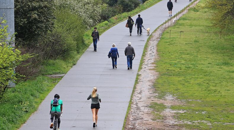 Pedestrians take advantage of a break in the rain on Tuesday, March 24, 2020, at the Atlanta BeltLine in Atlanta. Both Piedmont Park and the BeltLine are open although the city remains under a shelter at home order. (Christina Matacotta, for The Atlanta Journal-Constitution)