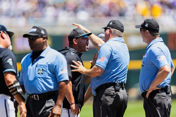 Coastal Carolina head coach Kevin Schnall, center left, screams at the umpires after being ejected in the first inning against LSU in Game 2 of the NCAA College World Series baseball finals in Omaha, Neb., Sunday, June 22, 2025. (AP Photo/Rebecca S. Gratz)