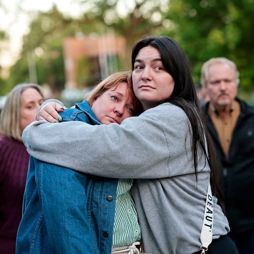 Diana Winther, left, and Kellie Webber, embrace during an evening prayer and vigil in support for the victims and their families impacted by Nippon Dynawave Packaging Co. tank implosion, at R.A. Long Park in Longview, Wash., on Tuesday, May 26, 2026. (Karen Ducey/The Seattle Times via AP)