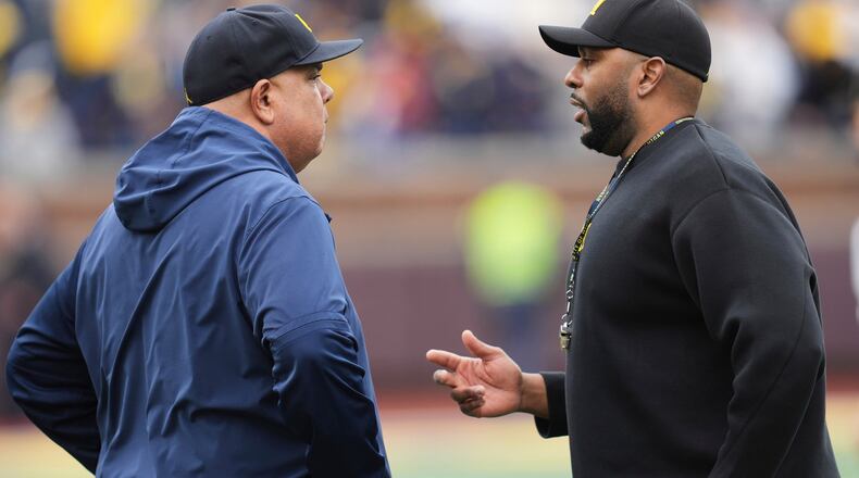 FILE - Michigan athletic director Warde Manuel, left, talks with head coach Sherrone Moore, right, before an NCAA college football spring game in Ann Arbor, Mich., April 19, 2025. (AP Photo/Paul Sancya, file)