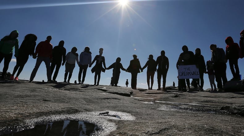 Participants gather for prayer after reaching the summit of Stone Mountain to commemorate the life of Dr. Martin Luther King, Jr., with children who aspire to be great during The Dream Walk in Stone Mountain. In his "I Have A Dream" speech, Dr. King spoke of a symbolic bell of freedom ringing from the top of Stone Mountain to the hills of Tennessee. Made with Canon EOS 1DX camera, a 16-35mm zoom lens at 16 mm, 1/4000 second, F/9, ISO 200. Curtis Compton / ccompton@ajc.com