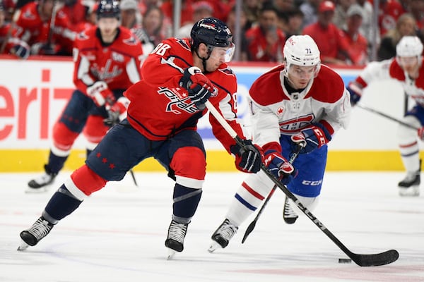 Washington Capitals left wing Andrew Mangiapane (88) and Montreal Canadiens center Jake Evans (71) battle for the puck in the first period of Game 1 of a first-round NHL hockey playoff series Monday, April 21, 2025, in Washington. (AP Photo/Nick Wass)