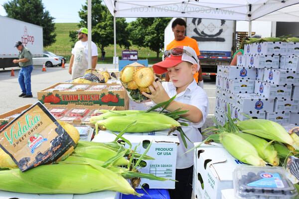 Five-year-old Rocky Mitchell of Vidalia came to Marietta in May to help pack vegetable boxes during the Georgia Grown fruit and vegetable sale. The State Department of Agriculture and other agencies set up a series of truck sale of Georgia produce to help farmers after COVID-19 shutdowns slowed demand for vegetables and fruits.