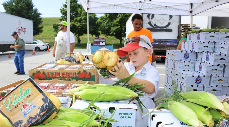 Five-year-old Rocky Mitchell of Vidalia came to Marietta in May to help pack vegetable boxes during the Georgia Grown fruit and vegetable sale. The State Department of Agriculture and other agencies set up a series of truck sale of Georgia produce to help farmers after COVID-19 shutdowns slowed demand for vegetables and fruits.