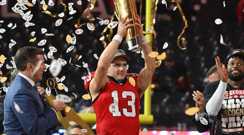 Georgia's quarterback Stetson Bennett (13) holds up the National Championship Trophy during the 2023 College Football Playoff National Championship game at SoFi Stadium, Monday, Jan. 9, 2023, in Inglewood, California.  The Bulldogs reportedly have yet to receive an invitation to visit the White House in Washington, D.C. (Hyosub Shin/The Atlanta Journal-Constitution)