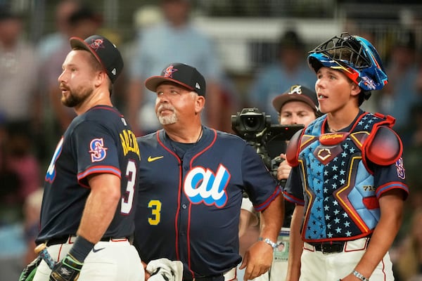 Seattle Mariners' Cal Raleigh, watches with his dad Todd who pitched and brother Todd Jr. catcher during the MLB baseball All-Star Home Run Derby, Monday, July 14, 2025, in Atlanta. (AP Photo/Brynn Anderson)