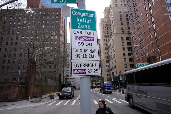 FILE - Signs advising drivers of congestion pricing tolls are displayed near the exit of the Lincoln Tunnel in New York, Wednesday, Feb. 19, 2025. (AP Photo/Seth Wenig, File)