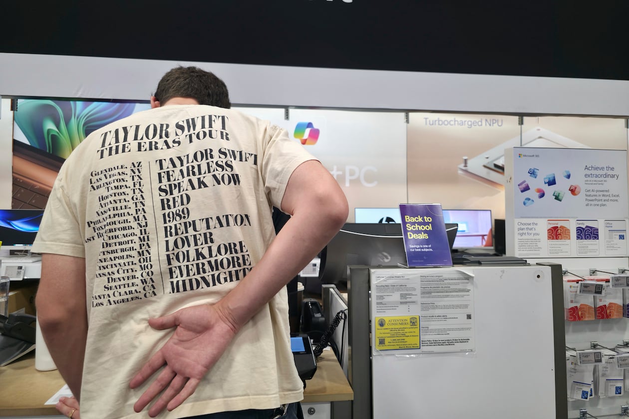 FILE - Middle school teacher Jeremy Hook shops for the latests Microsoft's Surface Laptop Copilot+ PC's at Best Buy Atwater Village store in Glendale, Calif., Tuesday, July 29, 2025. (AP Photo/Damian Dovarganes, File)