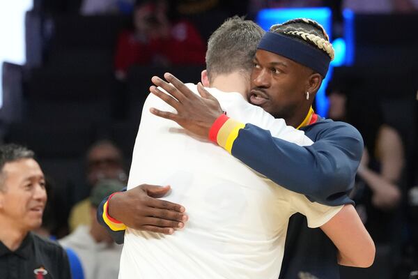 Golden State Warriors forward Jimmy Butler hugs former teammate Miami Heat forward Kevin Love before the first half of an NBA basketball game, Tuesday, March 25, 2025, in Miami. (AP Photo/Marta Lavandier)