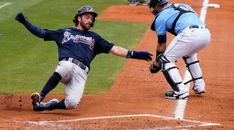 Braves shortstop Dansby Swanson (7) scores ahead of the throw to Tampa Bay Rays catcher Mike Zunino (10) on a two-run base hit by Jake Lamb in the second inning Sunday, March 21, 2021, in Port Charlotte, Fla. (John Bazemore/AP)